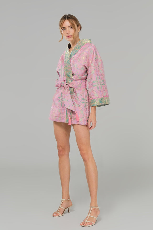 Woman wearing a pink patterned kimano on a gray background